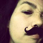 f83af0ed2281a1bd1a1251e36fa0a1ac A man with a mustache is looking at the camera.