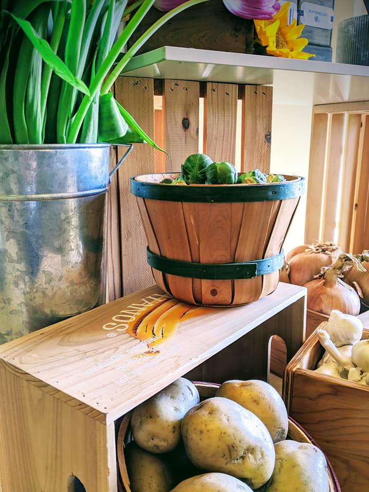 A wooden crate with some vegetables in it