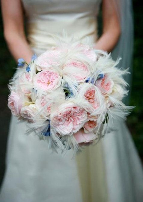 A bride holding her bouquet of flowers.