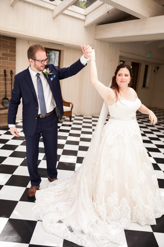 A man and woman holding hands in front of a checkered floor.