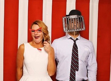 A man and woman posing for a photo booth picture.