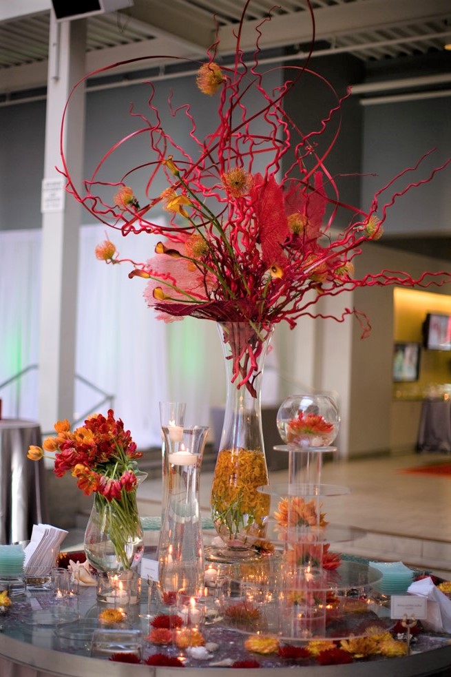 A table with flowers and candy in vases.
