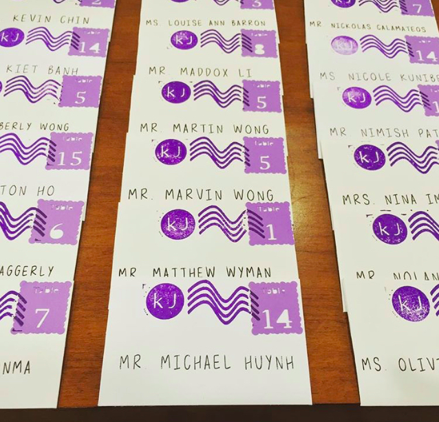 A table with many purple and white cards on it