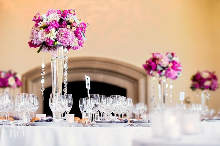 A table set with wine glasses and flowers.