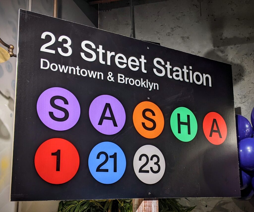 A sign that says sasha 1 2 3 and sasha 2 3 street station.