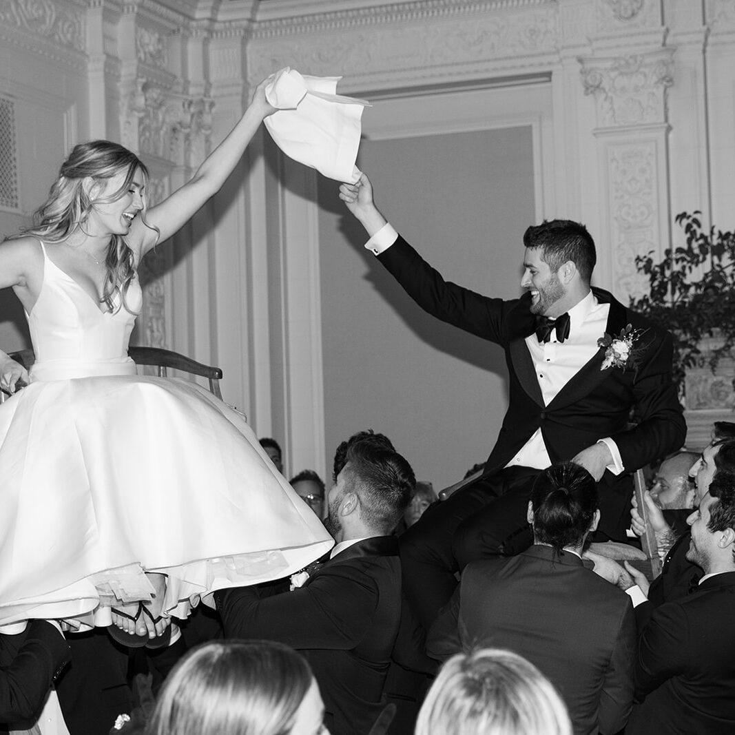 A bride and groom are dancing in front of the crowd.