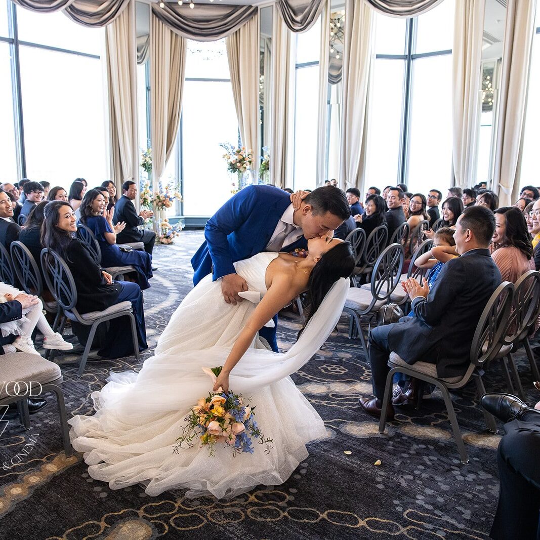 Michelle + Felix | SF Westin St. Francis A bride and groom kissing in front of an audience.
