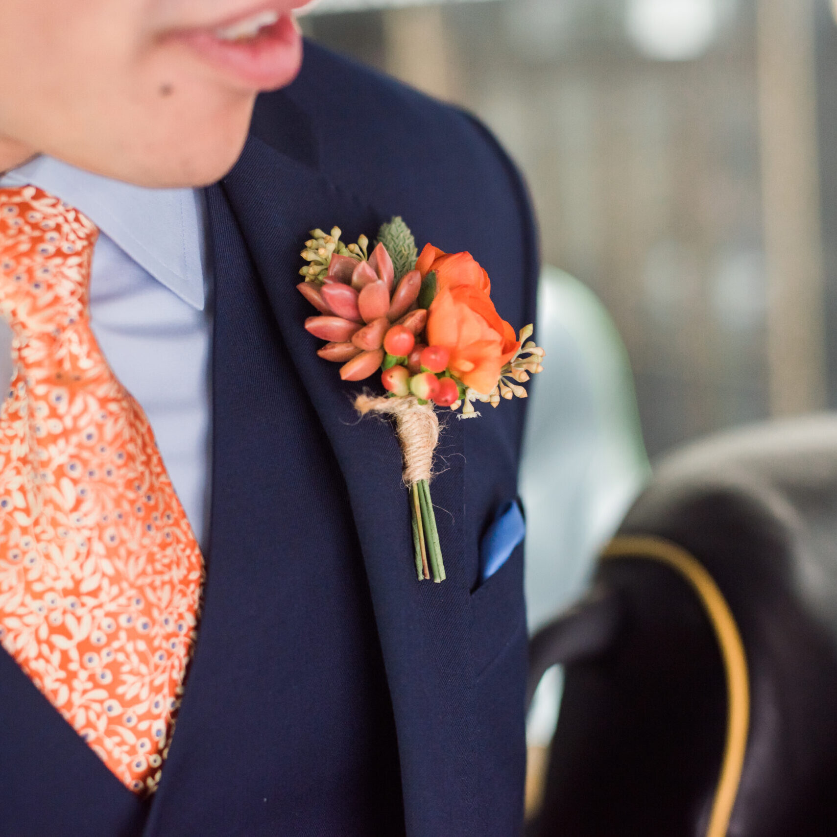 10-1 A man wearing an orange tie and blue suit.