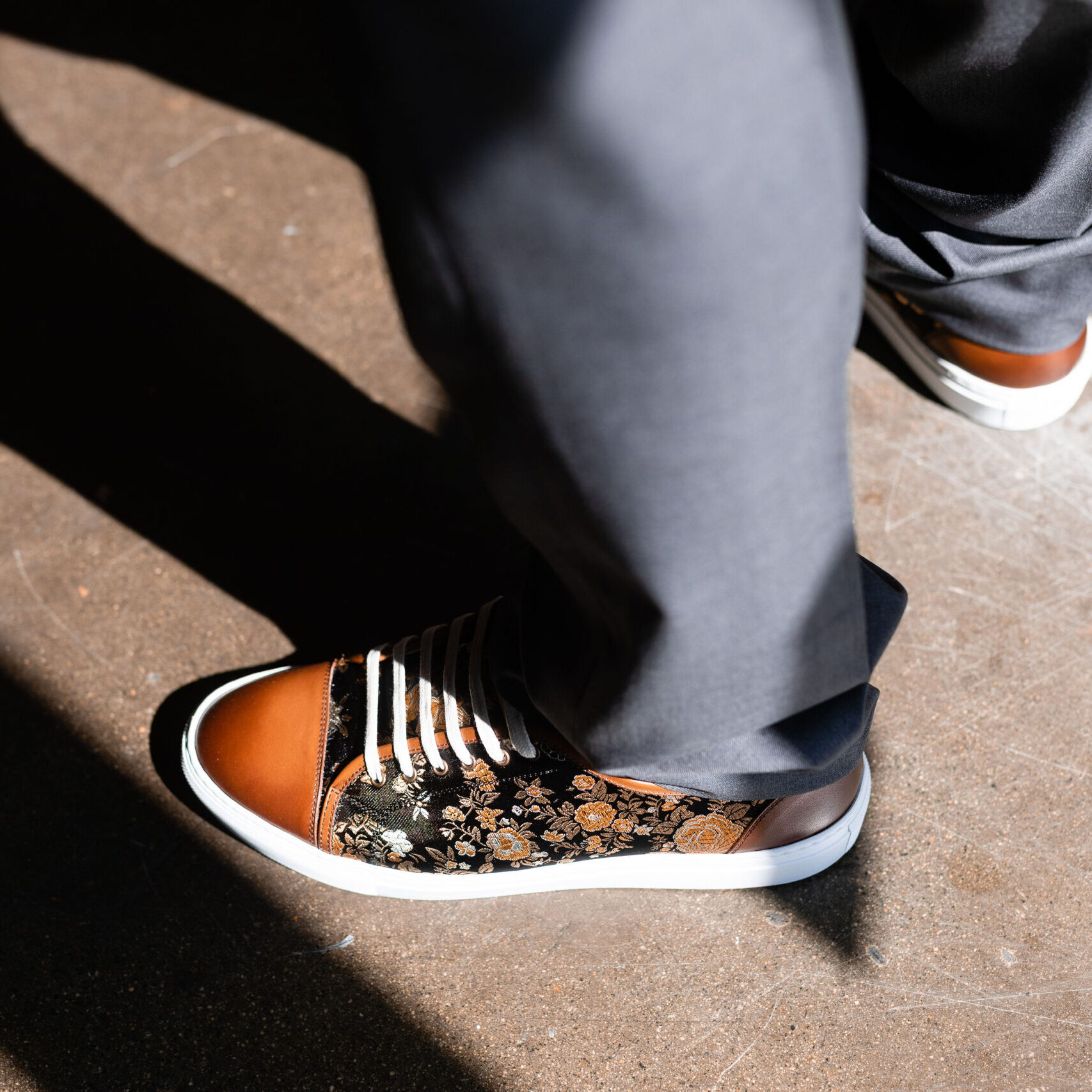 Dennis A person wearing orange and white shoes on the ground.