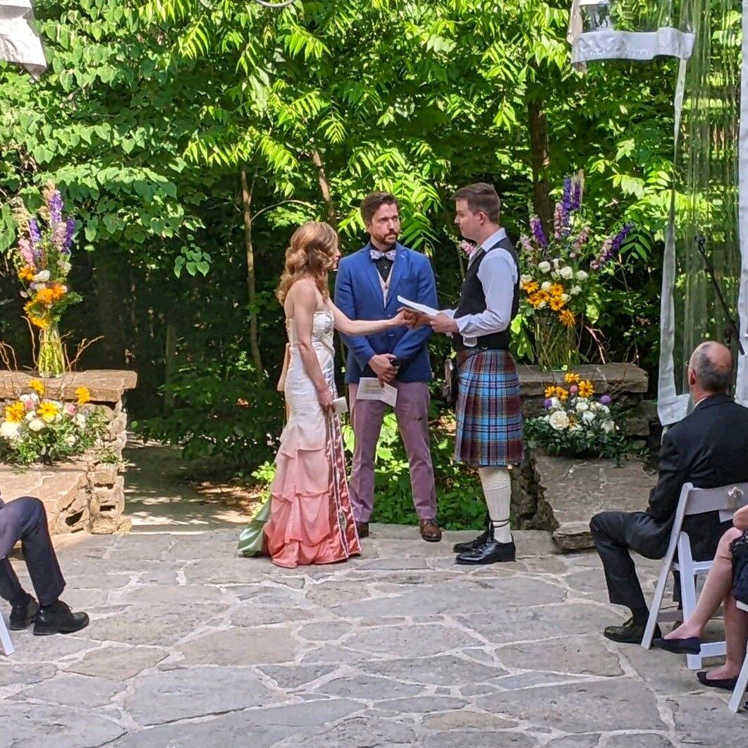 A couple getting married in an outdoor ceremony.
