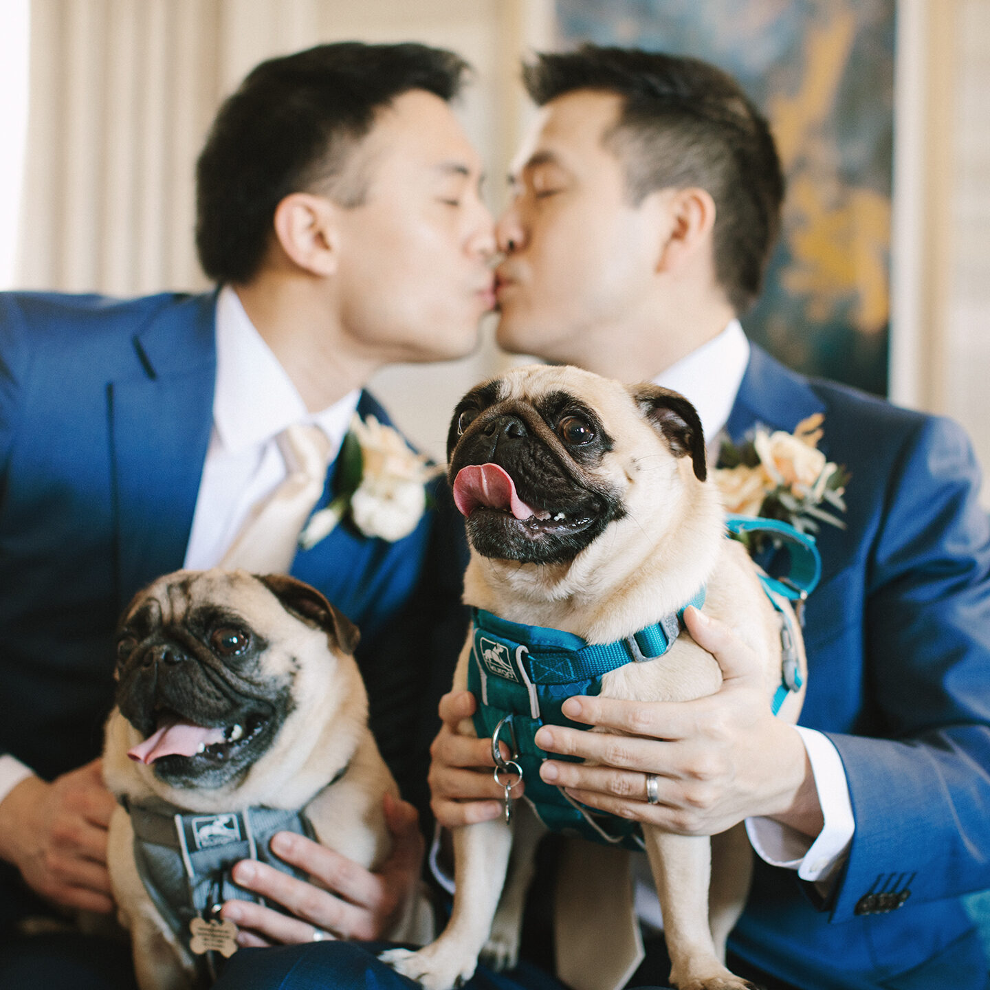 SneakPeek1 Two men kissing each other while holding a pug dog.