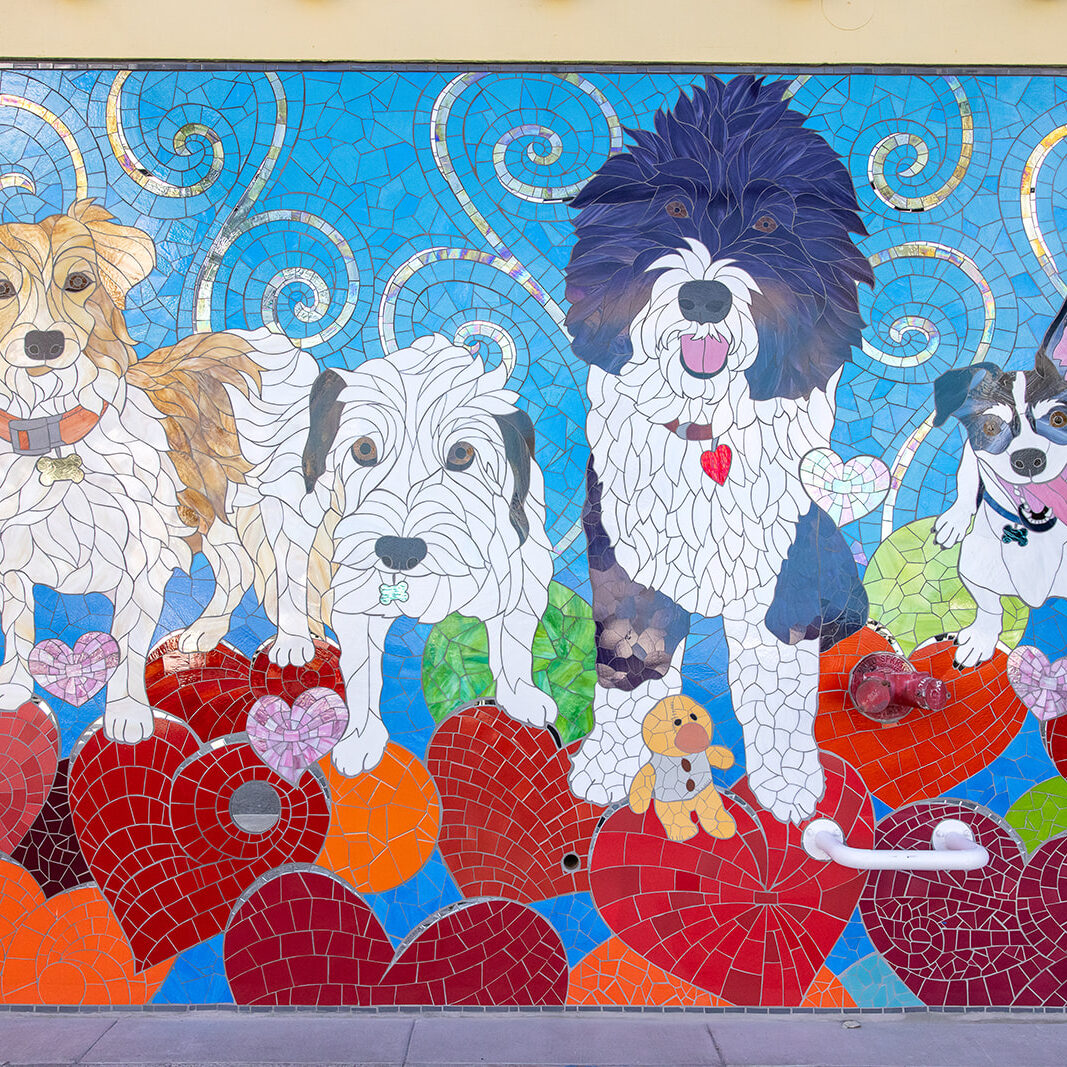 Muttville Ribbon Cutting Celebration A mosaic of four dogs with hearts on the ground.
