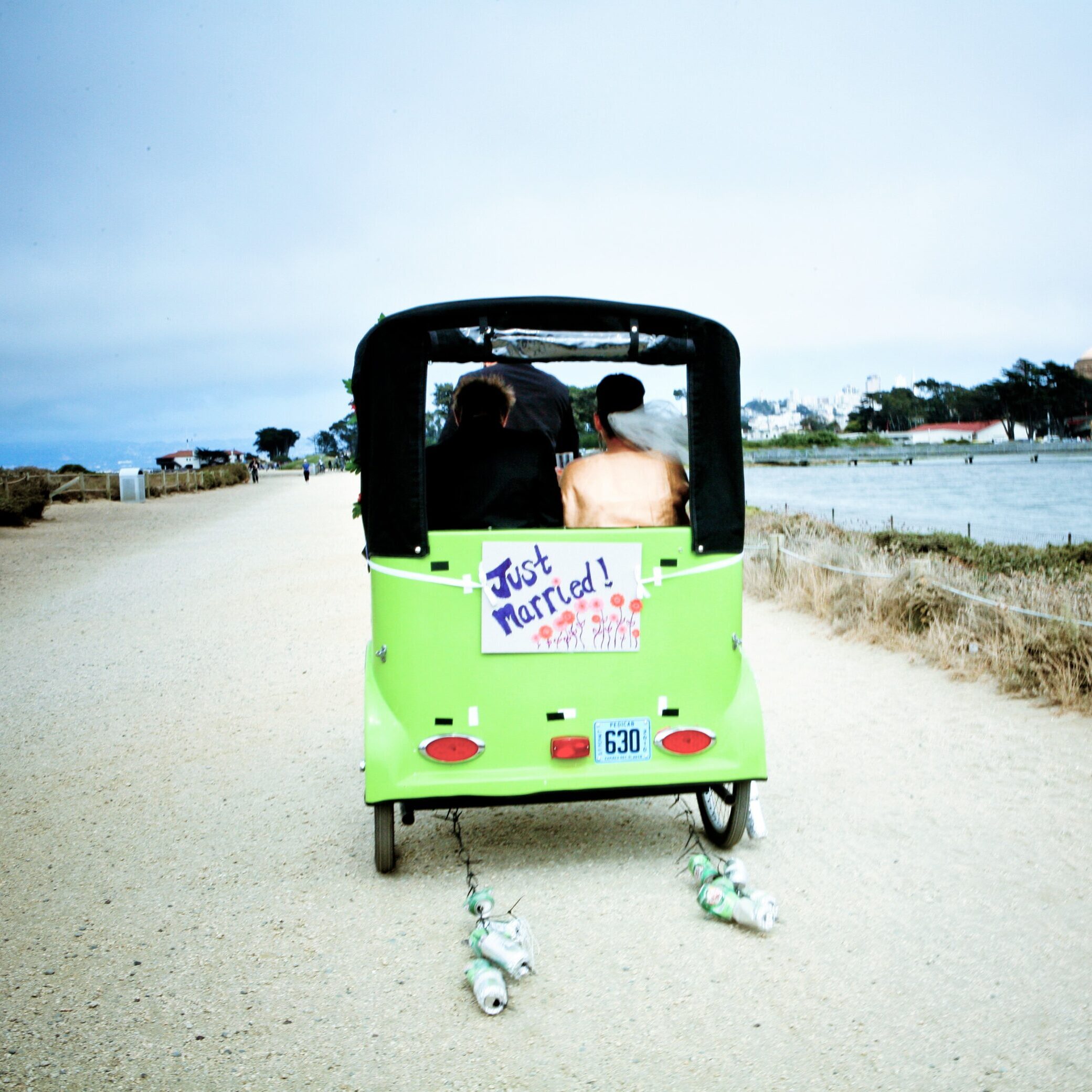 green 1 A couple is riding in the back of a green cart.
