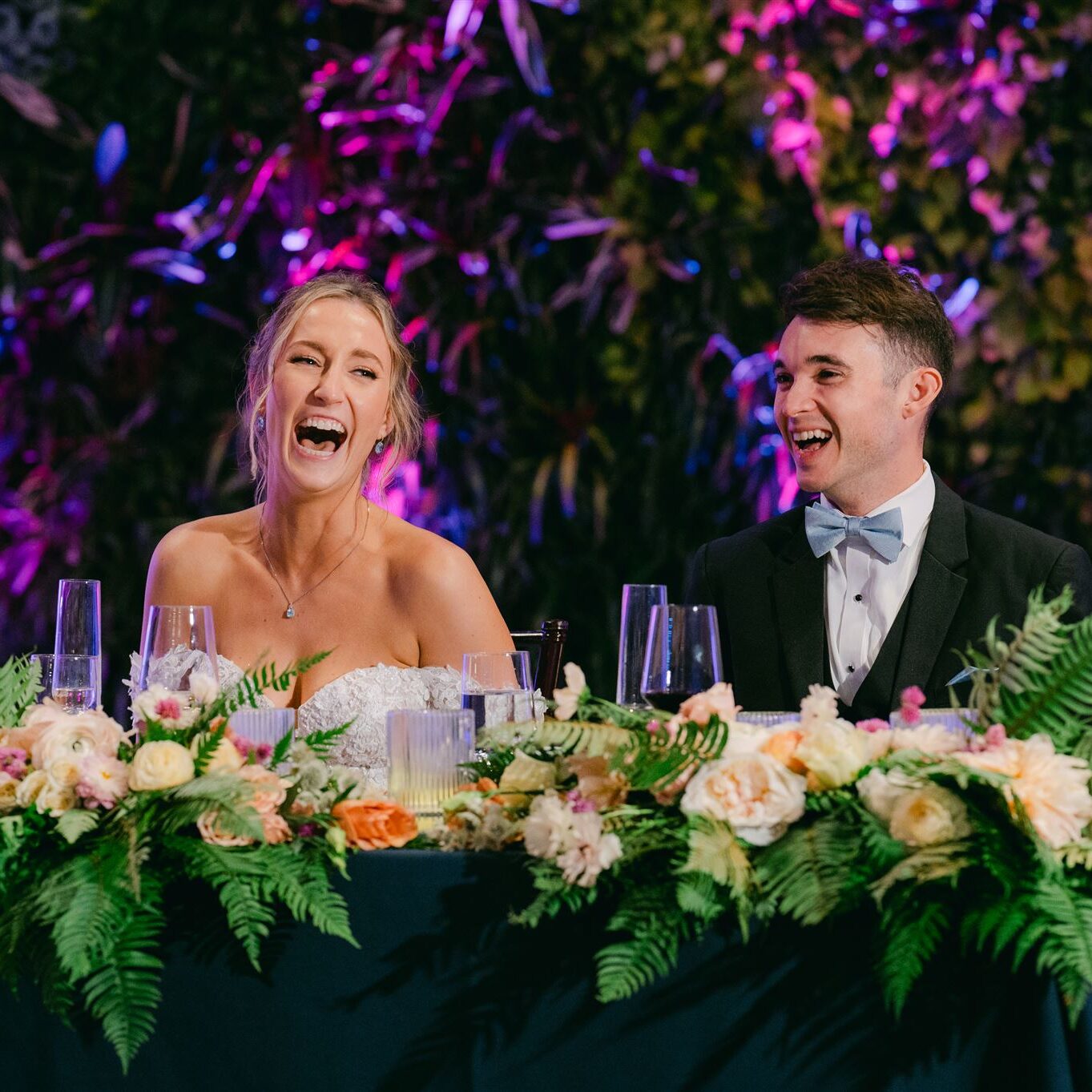 A man and woman sitting at the head table laughing.